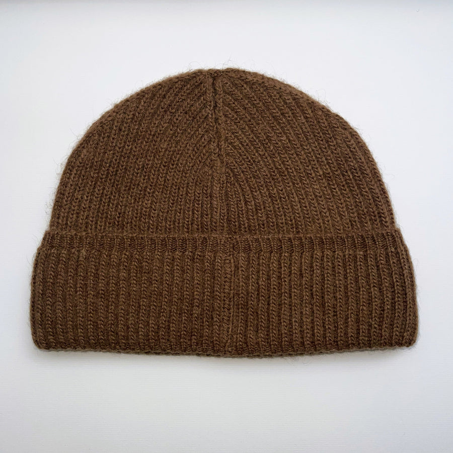 Camel brown knit beanie with a label on a white background