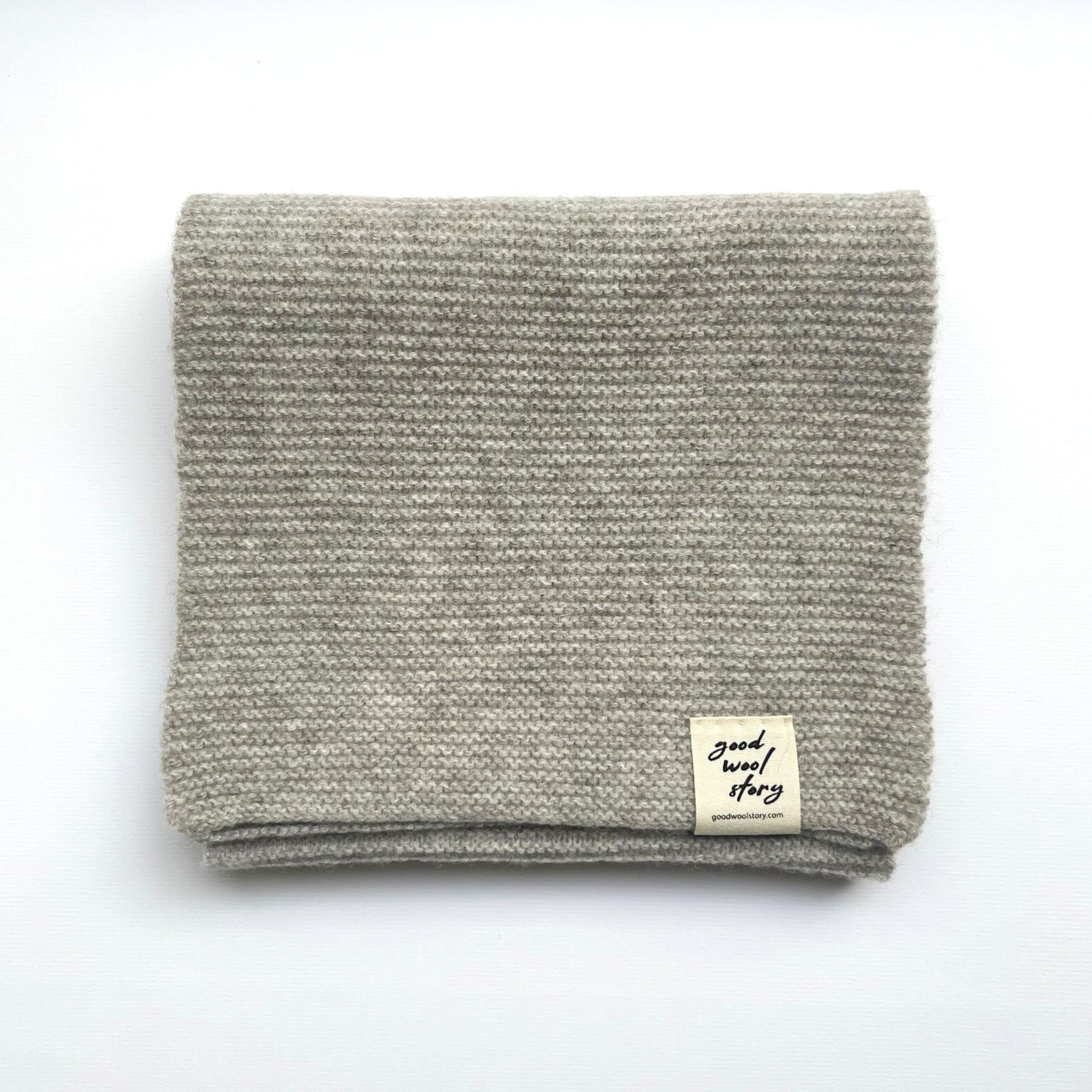 Gray knitted scarf with a label on a white background