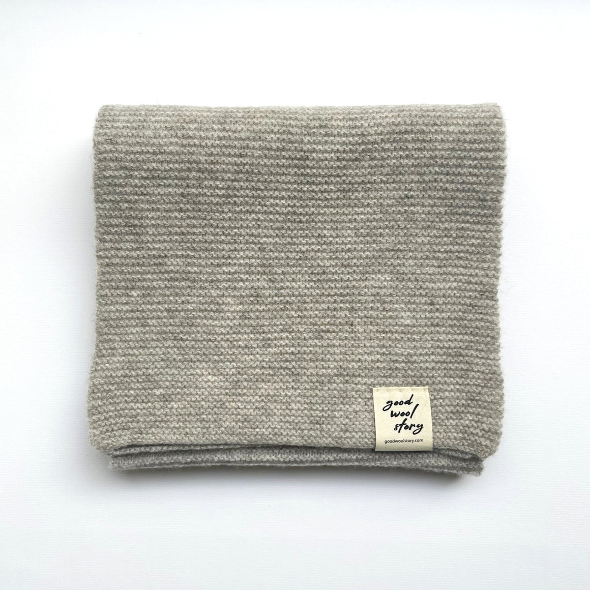 Gray knitted scarf with a label on a white background