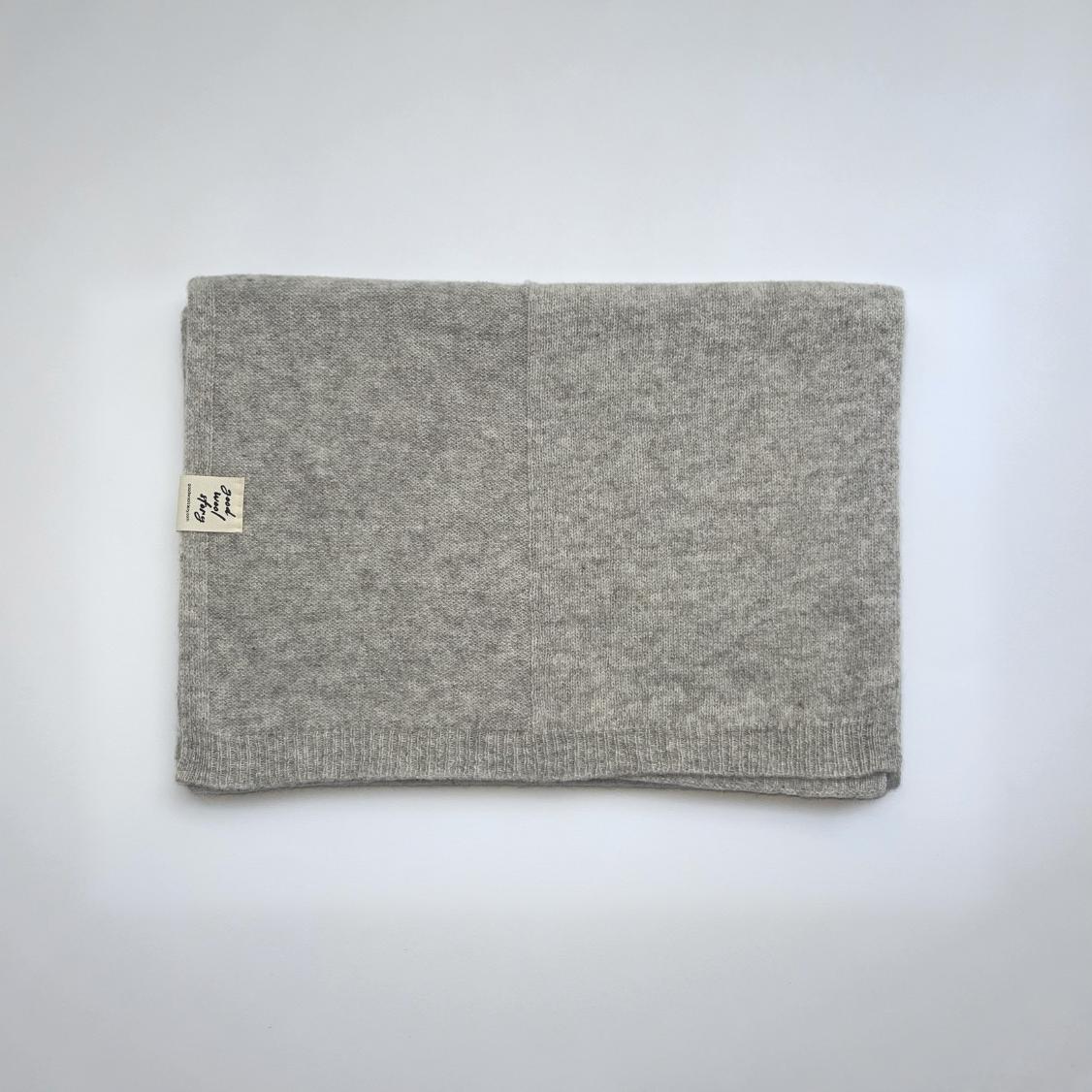 grey knitted scarf folded on a white background