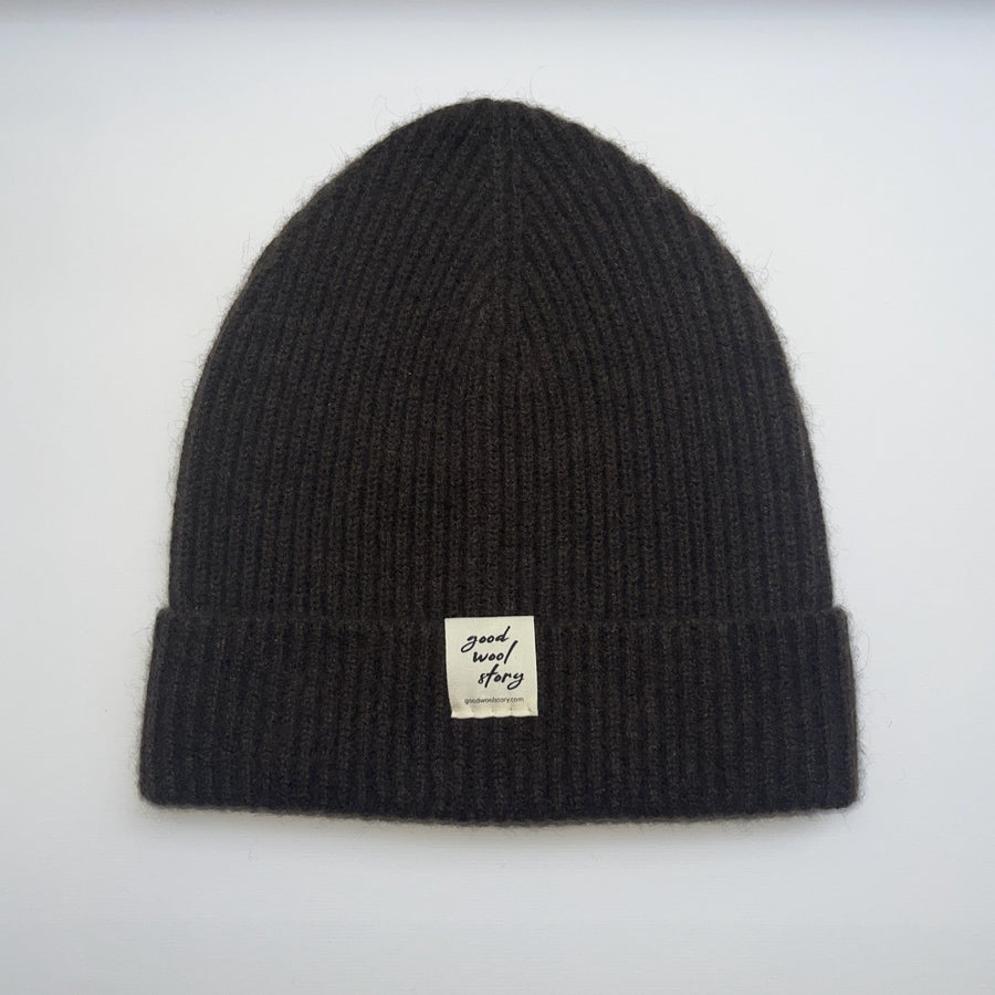 Brown knit beanie with a label on a white background