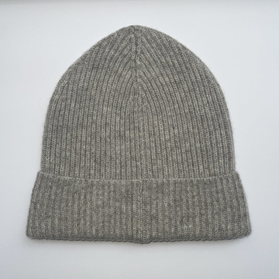 Gray knit beanie with a label on a light gray background